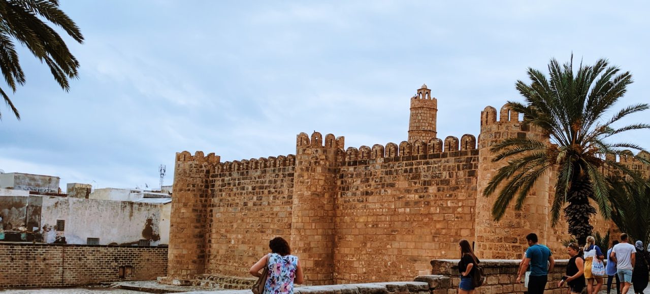 people standing beside concrete building at daytime