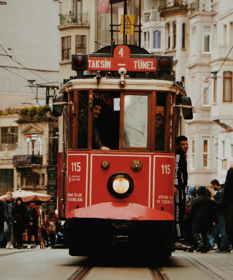 Iconic Istanbul tram navigating through a busy street, capturing urban life and architecture.