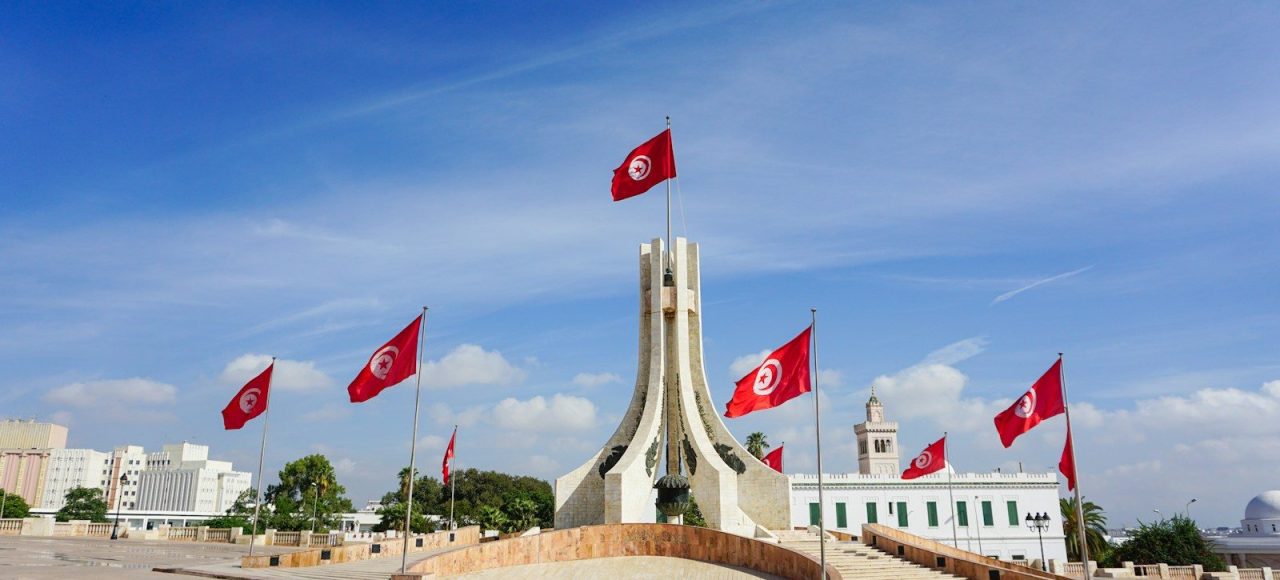 A monument with flags flying in the wind