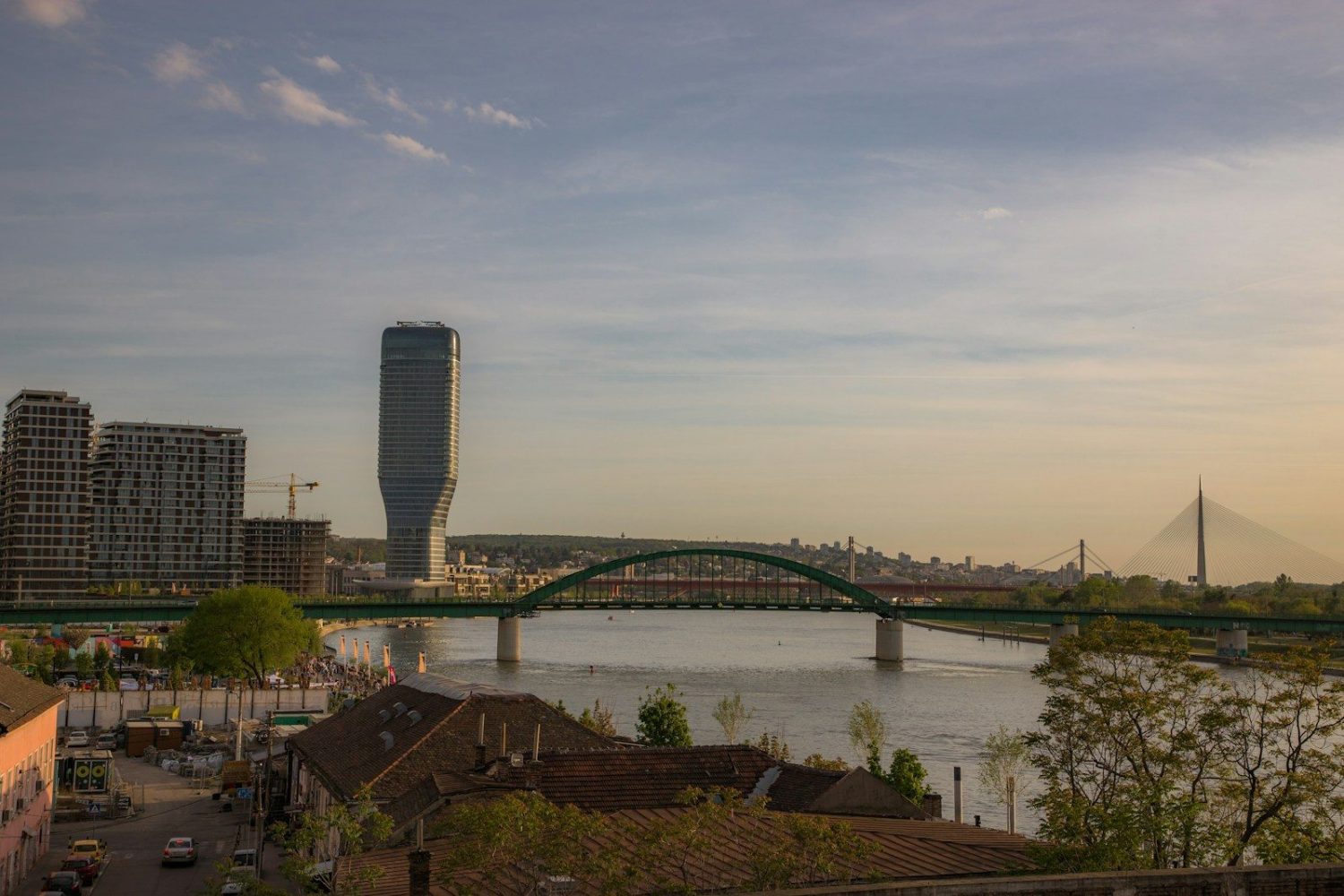 a bridge over a river with a city in the background
