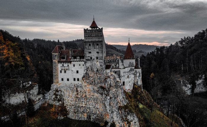 a castle on top of a mountain with a cloudy sky