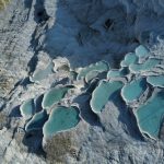 An aerial view of a rock formation with blue water