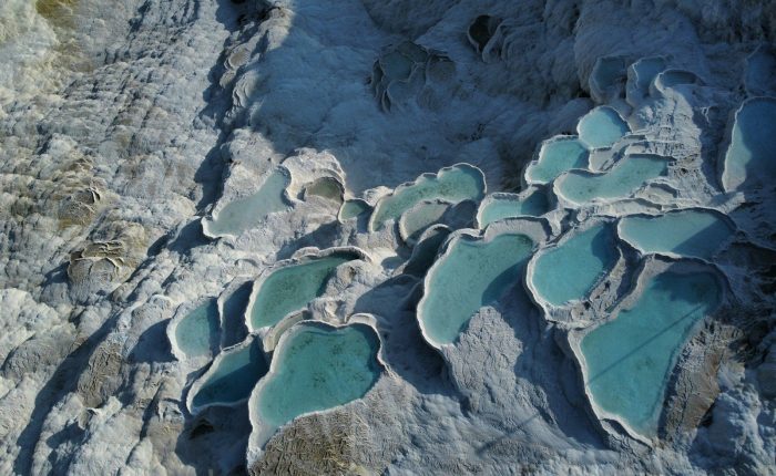 An aerial view of a rock formation with blue water